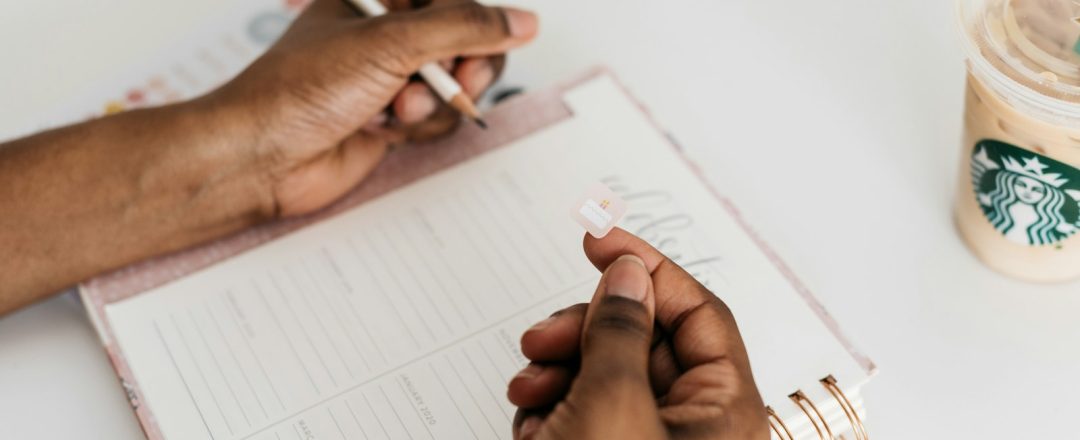 Mão de pessoa prestes a escrever em caderno, foto real