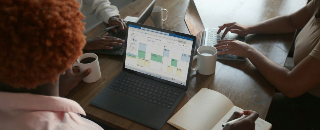 Equipe reunida discutindo cronograma em laptop, foto real